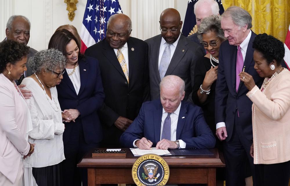 President Joe Biden signs Juneteenth National Independence Day Act surrounded by the Vice President, Senators, & Representatives