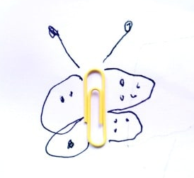 A butterfly drawn on paper with a yellow paperclip as its body