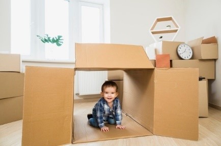 Child playing in a cardboard box