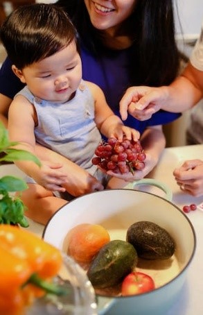 Child Eating Grapes and Other Fruits