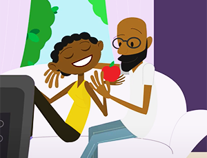 African American father and child sitting on a sofa talking
