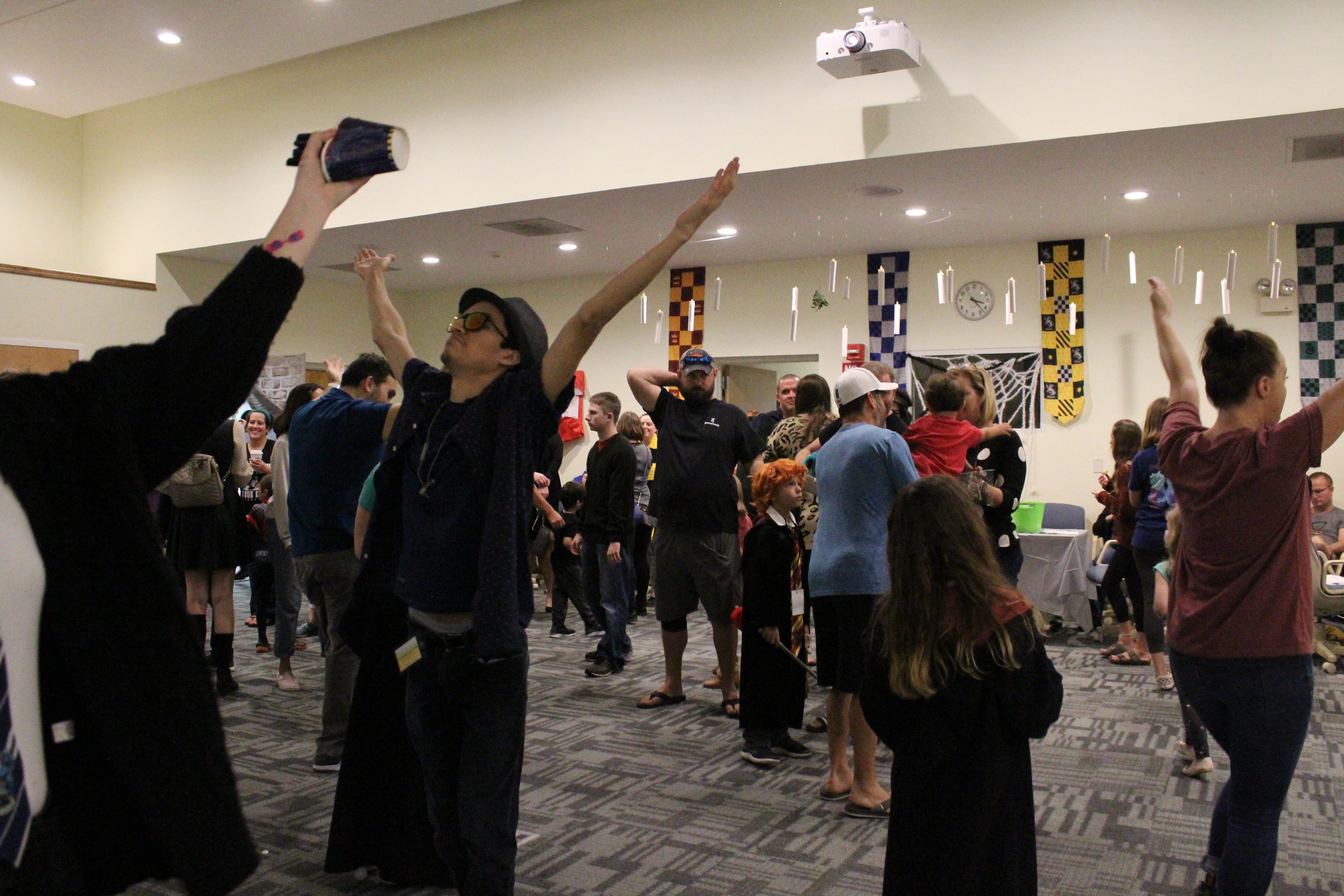 Several cosplayers dance in wizards robes at the library