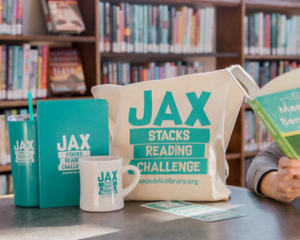 Photo of Jax Stacks-branded prizes including a tote, mug, tumbler and notebook