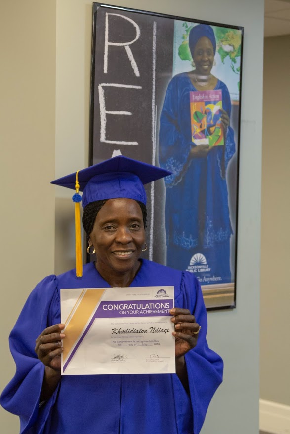 Khadi standing by her READ poster in the Center for Adult Learning