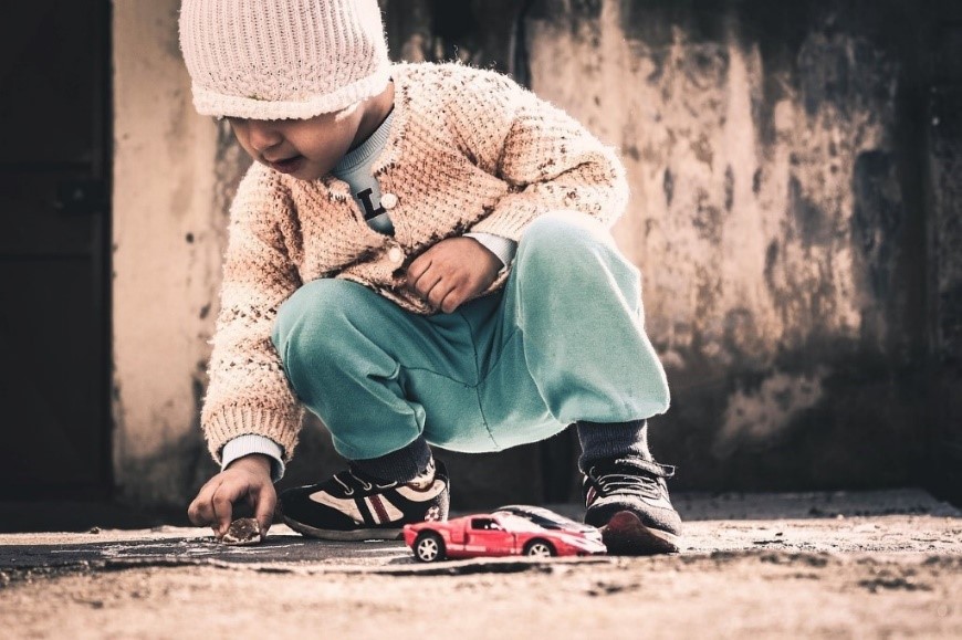 Photo of little kid playing with toy cars