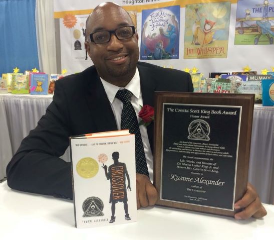 Kwame Alexander with his book Crossover and a Coretta Scott King Award