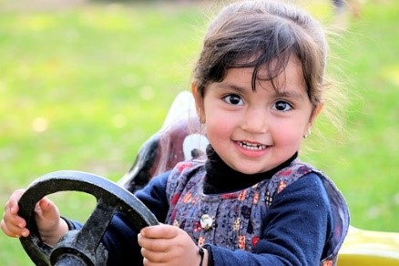 Child holding a steering wheel
