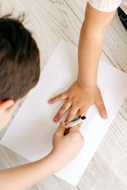 Children tracing their hand on paper
