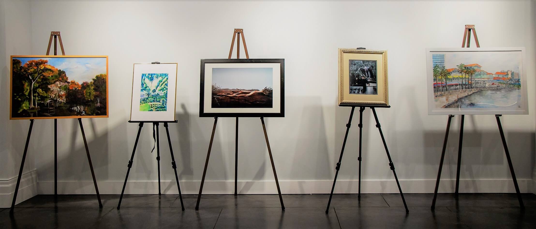 Five pieces of artwork, displayed on easels