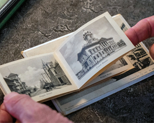 Image of someone turining the pages in a book of illustrations in the Florida Collection