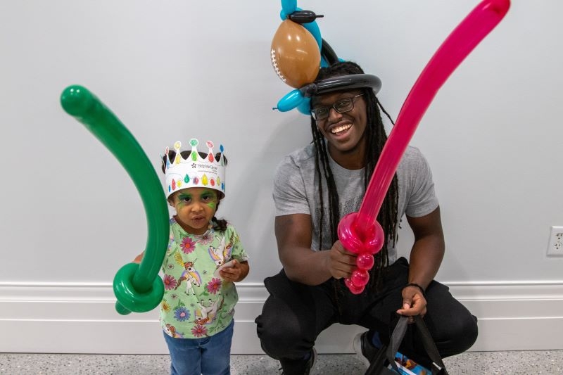 A father and his daughter pose with balloon swords