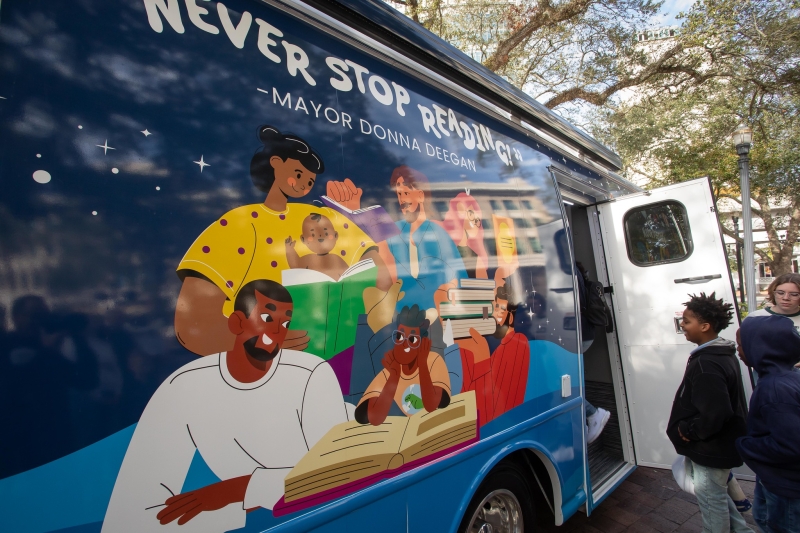 A child enters the bookmobile from the door on the side