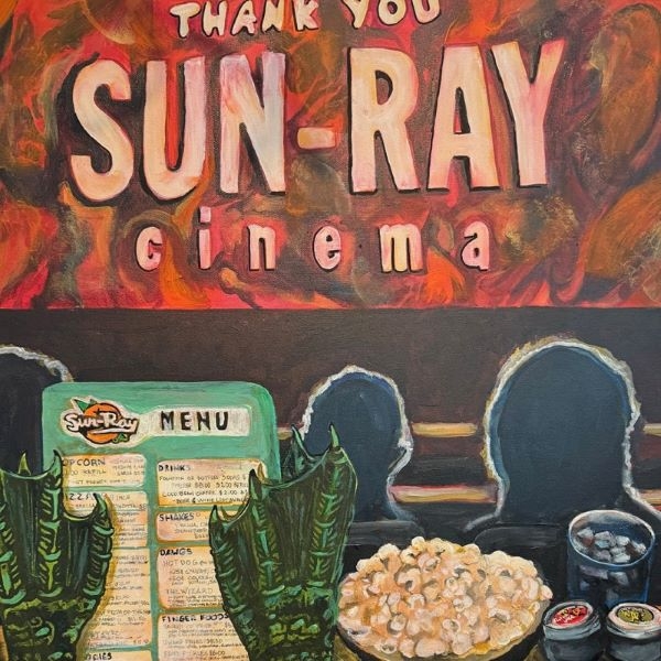 Painting of a monster's feet on the back of a theatre seat. The screen reads, "Thank You Sun-Ray Cinema"