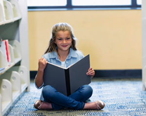 Young girl reading a book in the library