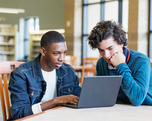 Two male students using a laptop and hotspot from the Jacksonville Public Library