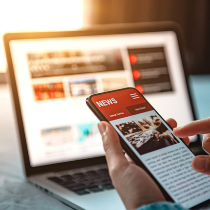 reading a mobile device and laptop for news