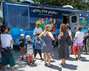 People visiting the Bookmobile at a Library outreach event