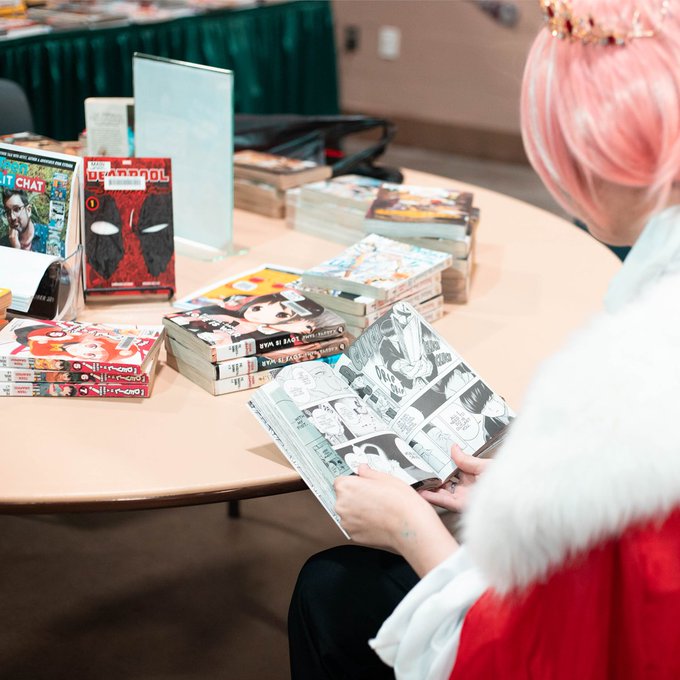 person reading manga at a table