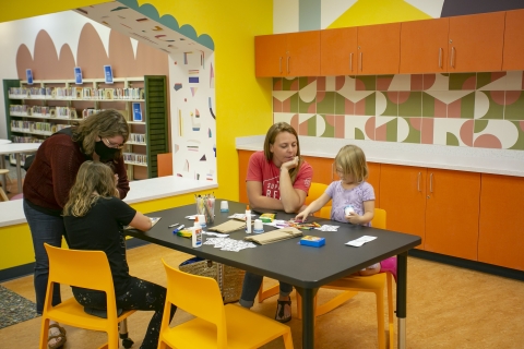 Parents and children participate in an activity at one of the craft stations