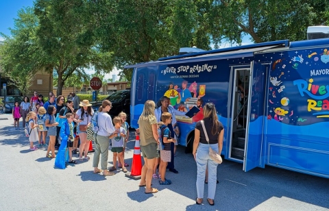 A crowd waits in line outside the bookmobile