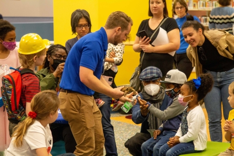 Zoo employee showing a turtle to a group of children