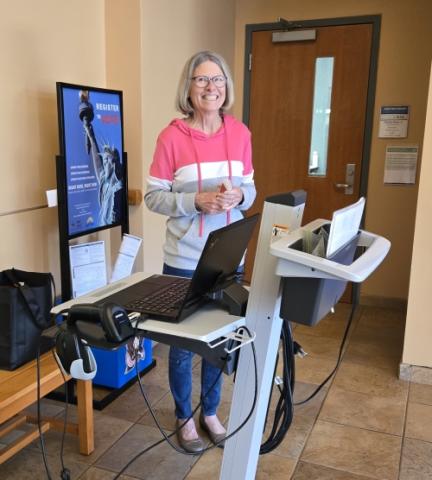 Volunteer Sue is ready to check in customers.