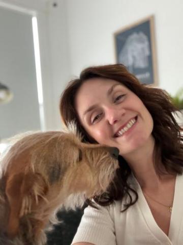 Smiling library volunteer Lara with her dog.