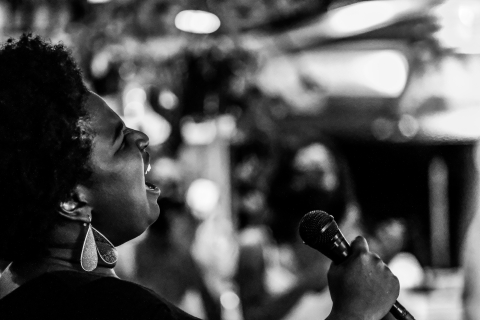 Photo of a woman singing, holding a microphone