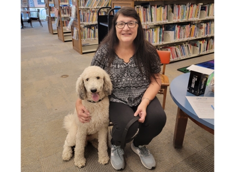 Volunteer woman and her dog at library