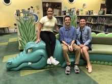 Jenna and Hurley with Dr. Adam Rosenblatt sitting on the Alligator couch in the Main Children's Library