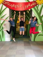 Photo of Hurley, Terri and Jenna jumping in mid air in front of the Children's Library at the Main Library