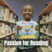 Young girl holding Pete the Cat book between library bookshelves