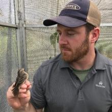 Andrew Schumann with a little bird on perched on his finger