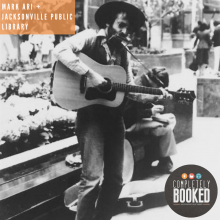 old black and white photo of Mark Ari playing a guitar