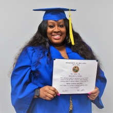 Tiffaney Capers in cap and gown, holding her diploma