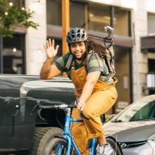 Photo of Mr. Joe Gaskin riding a bike around town