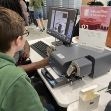 History Fair Help: Photo shows kids using a microfilm scanner at the library